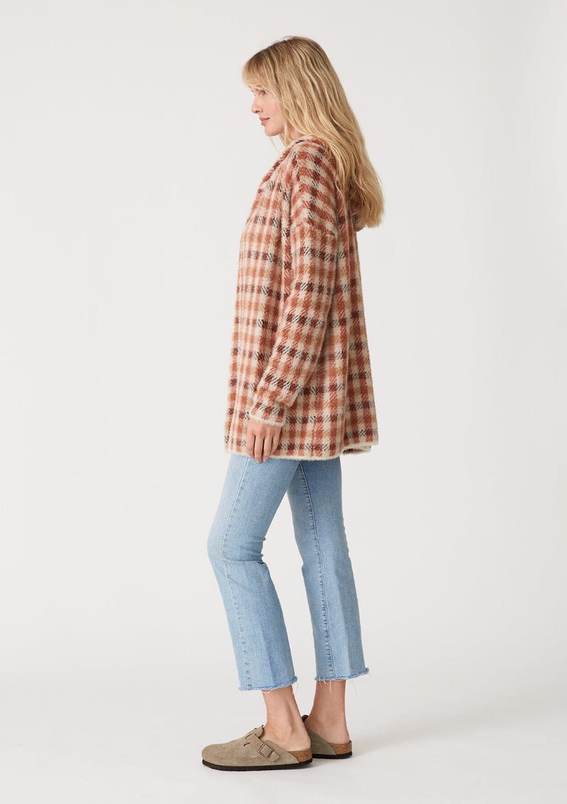 [Color: Rust/Natural] A side facing image of a blonde model wearing a fuzzy hooded cardigan in a brown plaid check design. With long sleeves and an open front.