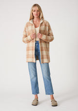 [Color: Taupe/Blue] A full body front facing image of a blonde model wearing a fuzzy hooded cardigan in a brown plaid design. With long sleeves and an open front. 