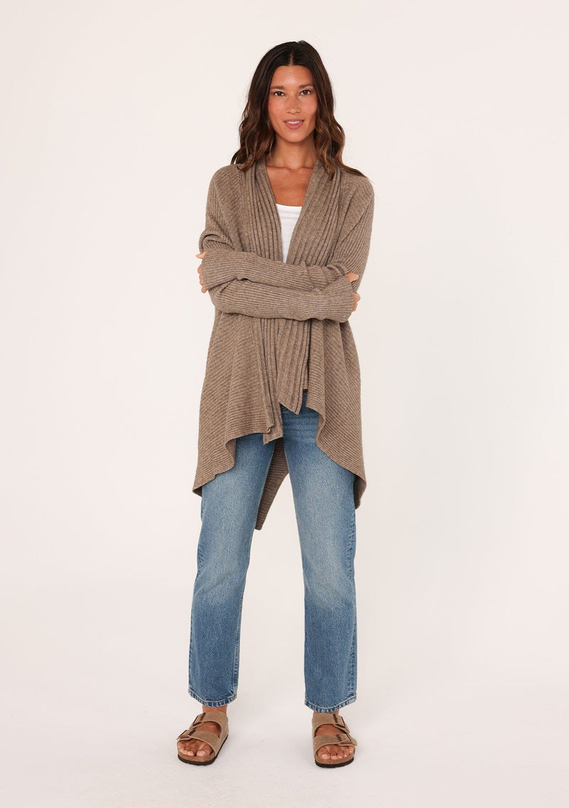 [Color: Mushroom] A front facing image of a brunette model wearing a brown shawl cardigan with a ribbed texture, open front, and a back vent detail. Cozy and relaxed for the fall season. 