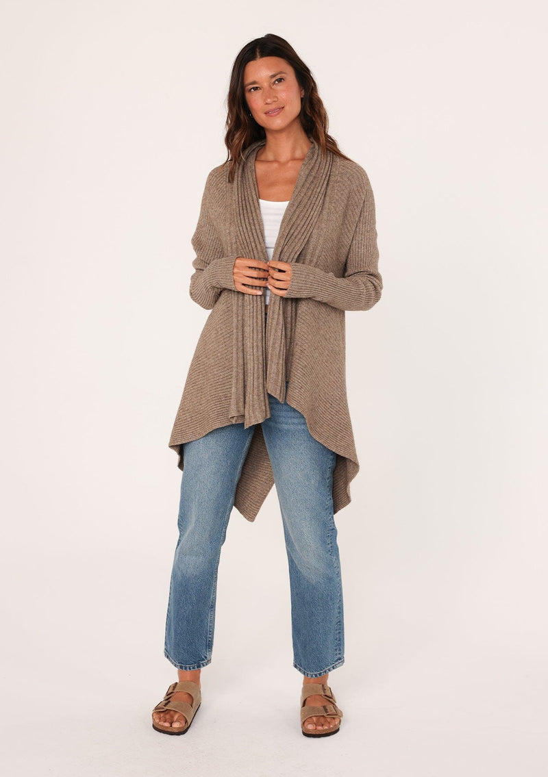 [Color: Mushroom] A front facing image of a brunette model wearing a brown shawl cardigan with a ribbed texture, open front, and a back vent detail. Cozy and relaxed for the fall season. 