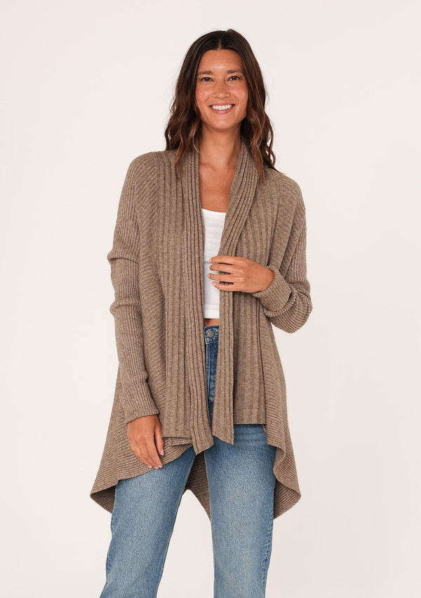 [Color: Mushroom] A front facing image of a brunette model wearing a brown shawl cardigan with a ribbed texture, open front, and a back vent detail. Cozy and relaxed for the fall season. 