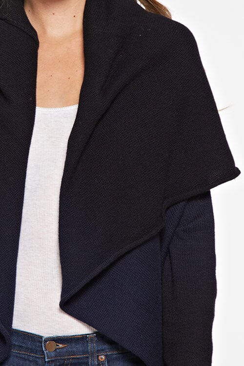 [Color: Navy/Black] A detail image of a blonde model wearing a dip dyed cocoon cardigan with a shawl collar and long sleeves. A versatile cardigan that can transition from a duster to a mid-length cardigan. 