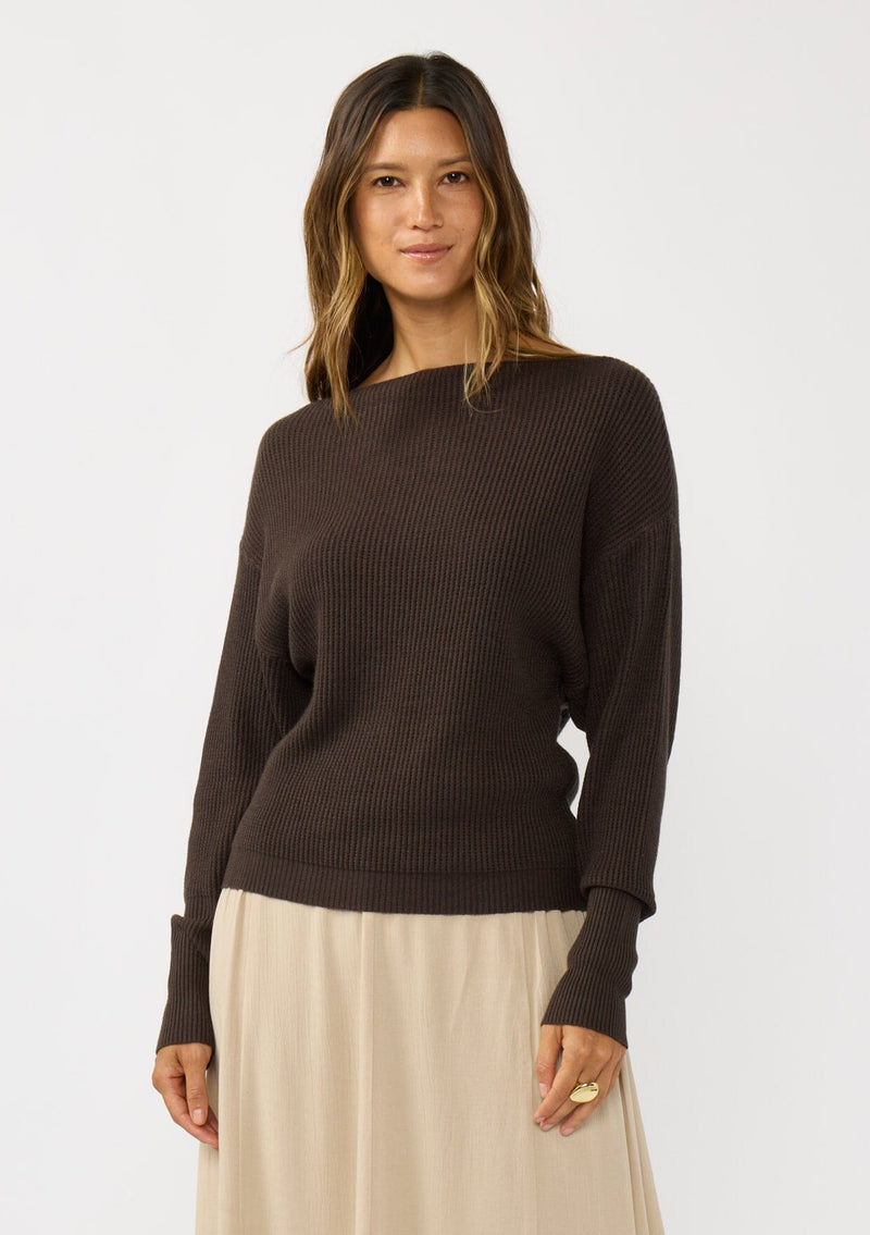 [Color: Dark Brown] A front facing image of a blonde model wearing a brown waffle knit pullover sweater. With long sleeves, a relaxed fit, and a wide neckline that can be worn off the shoulder.