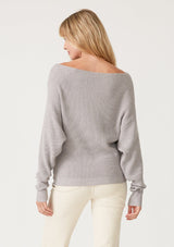 [Color: Light Heather Grey] A back facing image of a blonde model wearing a light heather grey waffle knit pullover sweater. With long sleeves, a relaxed fit, and a wide neckline that can be worn off the shoulder.