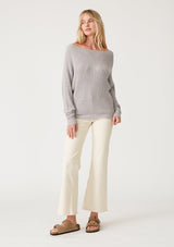 [Color: Light Heather Grey] A full body front facing image of a blonde model wearing a light heather grey waffle knit pullover sweater. With long sleeves, a relaxed fit, and a wide neckline that can be worn off the shoulder.