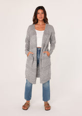[Color: Heather Grey] A front view of a brunette woman modeling a long, open-front gray mélange knit cardigan over a white top and blue jeans.
