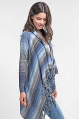 [Color: Heather Ocean/Grey] An image of a model wearing a striped shawl cardigan with a fringe trim and wrap button closure. 
