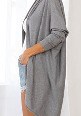 [Color: Heather Charcoal] A brunette model wearing a slouchy cardigan with a cocoon fit, shawl collar drape, and long dolman sleeves. This relaxed style is the perfect casual staple for any fall wardrobe. 