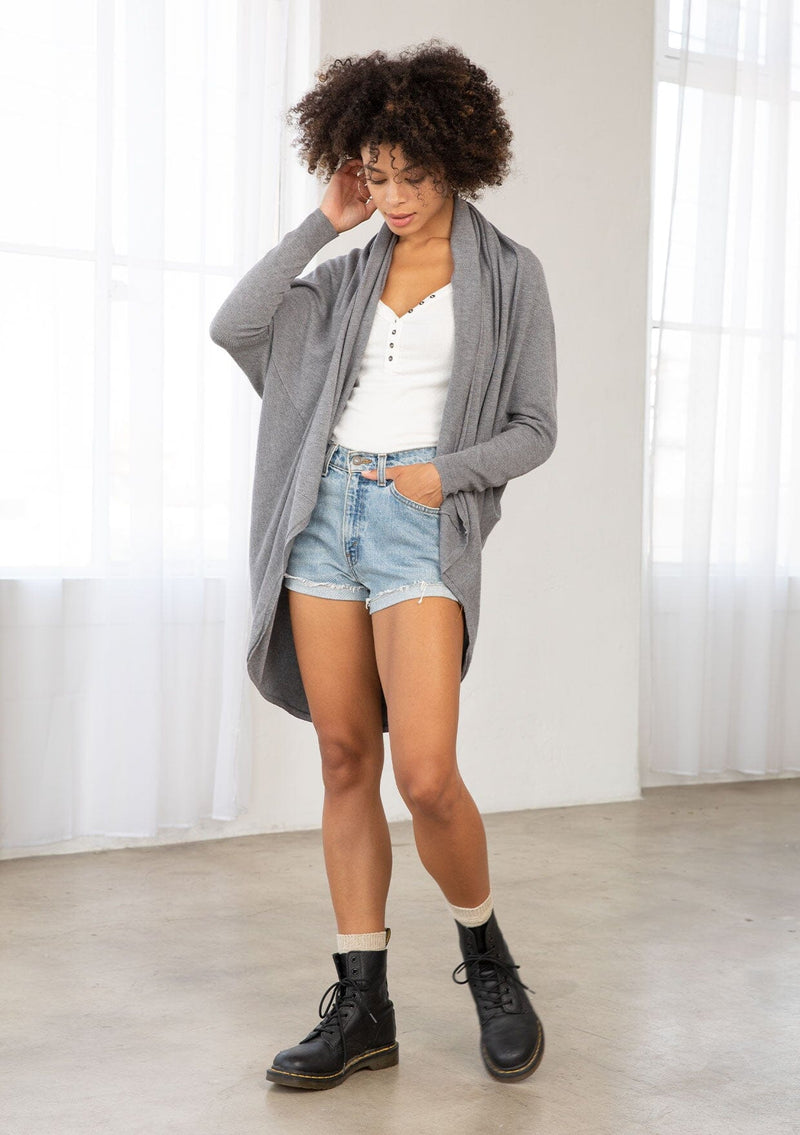 [Color: Heather Charcoal] A brunette model wearing a slouchy cardigan with a cocoon fit, shawl collar drape, and long dolman sleeves. This relaxed style is the perfect casual staple for any fall wardrobe. 