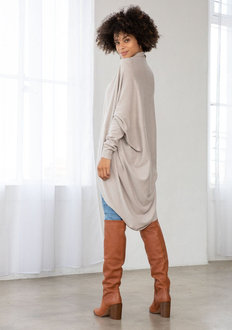 [Color: Heather Stone] A brunette model wearing a slouchy cardigan with a cocoon fit, shawl collar drape, and long dolman sleeves. This relaxed style is the perfect casual staple for any fall wardrobe. 