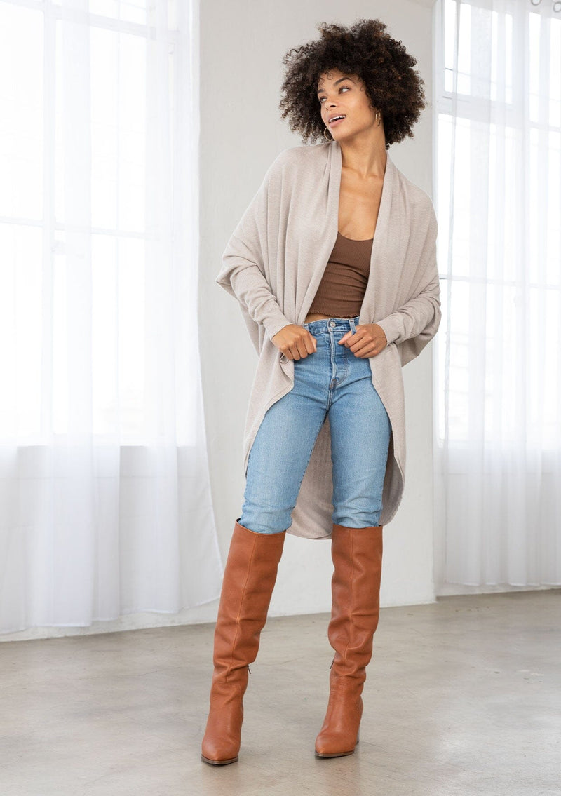 [Color: Heather Stone] A brunette model wearing a slouchy cardigan with a cocoon fit, shawl collar drape, and long dolman sleeves. This relaxed style is the perfect casual staple for any fall wardrobe. 