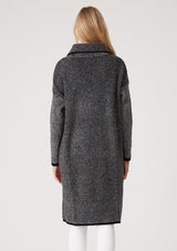 [Color: Black Multi] A back facing image of a blonde model wearing a black and white multi knit duster cardigan. A mid length cardigan sweater with an oversize collared neckline, a snap button front, side pockets, and contrast trim. 