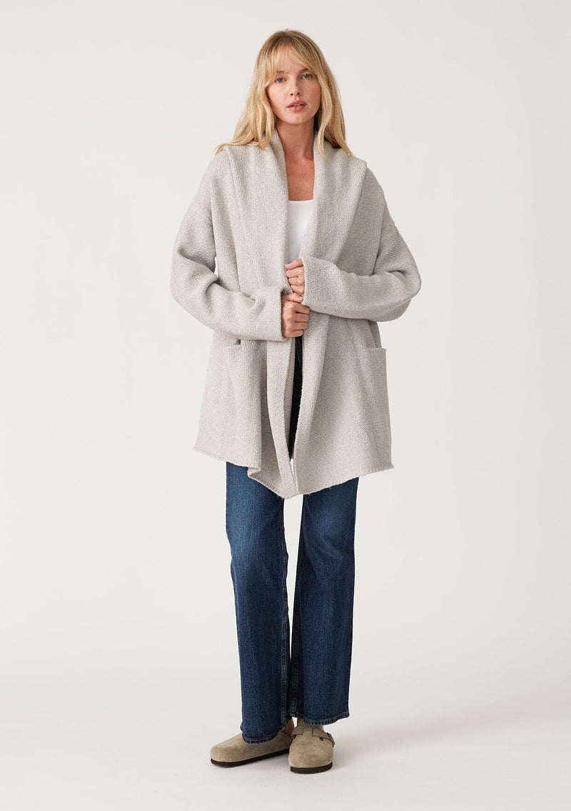 [Color: Heather Grey] A full body front facing image of a blonde model wearing an oversized sweater coat in heather grey. With an oversized hood, long sleeves, an open front, side pockets, and a mid length. 