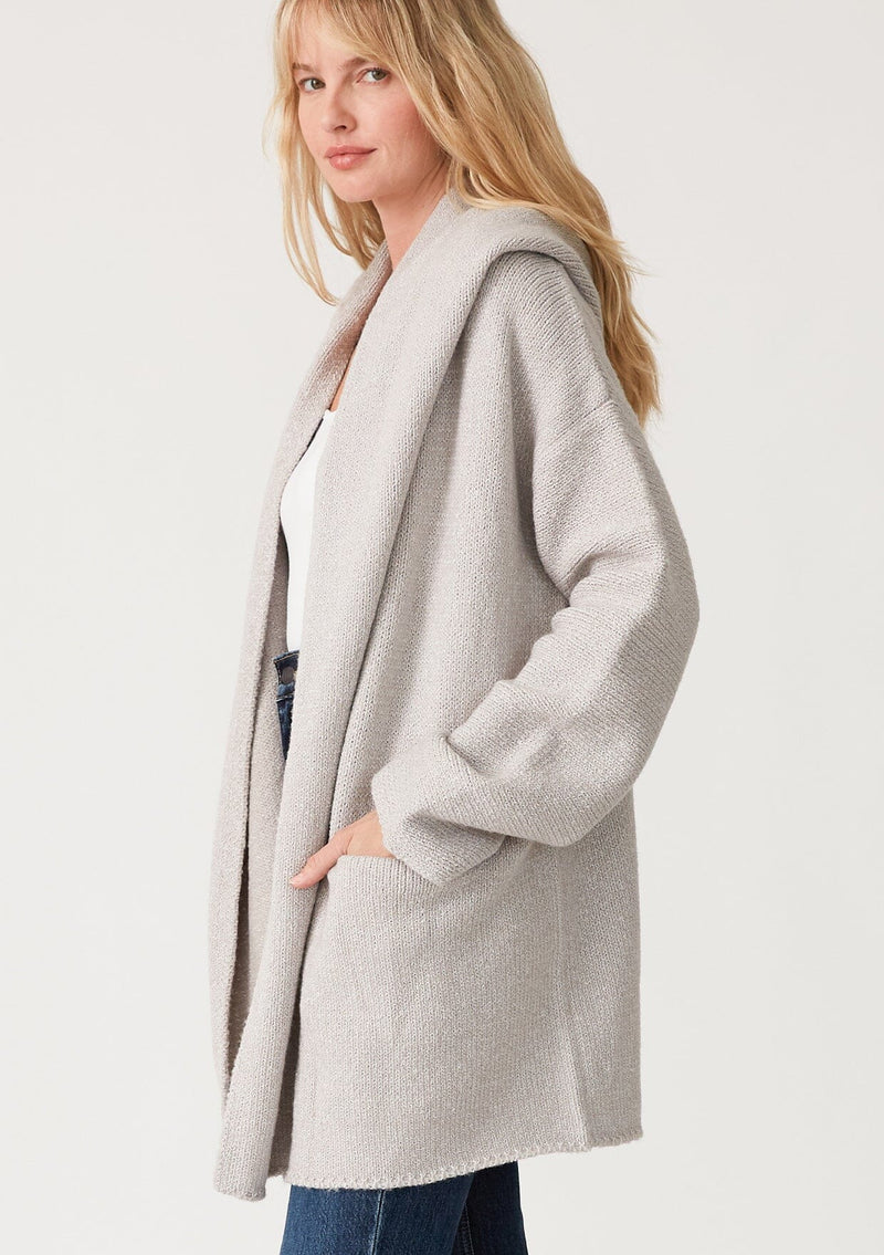 [Color: Heather Grey] A side facing image of a blonde model wearing an oversized sweater coat in heather grey. With an oversized hood, long sleeves, an open front, side pockets, and a mid length. 
