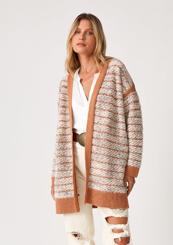 [Color: Mocha/Natural] A front facing image of a blonde model wearing a bohemian fall cardigan in a speckled loop knit stripe. With long sleeves, side pockets, an open front, and contrast brown ribbed trim.