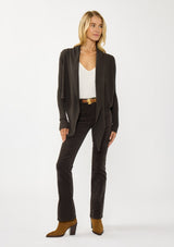 [Color: Dark Brown] A photo of a Lovestitch model wearing a chic brown waffle knit wrap front sweater with long sleeves, a v neckline, and a button closure at the back. The long ties can be styled in multiple ways.