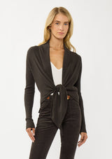 [Color: Dark Brown] A photo of a Lovestitch model wearing a chic brown waffle knit wrap front sweater with long sleeves, a v neckline, and a button closure at the back. The long ties can be styled in multiple ways.