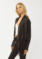 [Color: Dark Brown] A photo of a Lovestitch model wearing a chic brown waffle knit wrap front sweater with long sleeves, a v neckline, and a button closure at the back. The long ties can be styled in multiple ways.