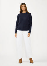 [Color: Navy] A front facing image of a brunette model wearing a classic crew neck sweater in navy blue. With ribbed trims, long sleeves, and a cable knit stitch detail. A versatile sweater perfect for layering.