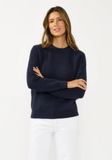 [Color: Navy] A front facing image of a brunette model wearing a classic crew neck sweater in navy blue. With ribbed trims, long sleeves, and a cable knit stitch detail. A versatile sweater perfect for layering.