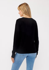 [Color: Black] A back facing image of a blonde model wearing a black solid knit sweater with a wrap front and side button closures. A soft versatile sweater, perfect for spring styling. 