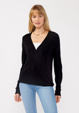 [Color: Black] A front facing image of a blonde model wearing a black solid knit sweater with a wrap front and side button closures. A soft versatile sweater, perfect for spring styling. 