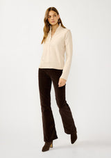 [Color: Dusty Blush] A front facing image of a blonde model wearing a cozy beige turtle neck sweater with a half zip front, long sleeves, and ribbed trims. A basic pullover sweater for the fall season. 