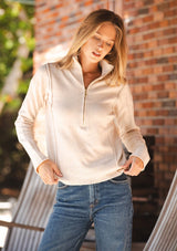 [Color: Dusty Blush] A front facing image of a blonde model wearing a cozy beige turtle neck sweater with a half zip front, long sleeves, and ribbed trims. A basic pullover sweater for the fall season. 