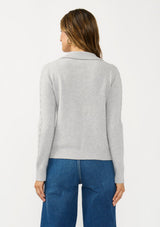 [Color: Heather Silver] A back facing image of a brunette model wearing a soft grey polo sweater with a collared neck, button front, and ribbed trim. 