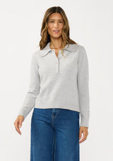 [Color: Heather Silver] A front facing image of a brunette model wearing a soft grey polo sweater with a collared neck, button front, and ribbed trim. 