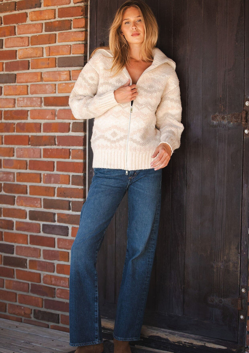 [Color: Natural/Dusty Pink] A front facing image of a blonde model wearing a beige southwestern boho sweater jacket with a zipper front and ribbed trims. A fall cozy sweater. 
