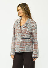 [Color: Charcoal] A side facing image of a brunette model wearing a southwestern fuzzy jacket with a notched collar, button front, and patch pockets. 
