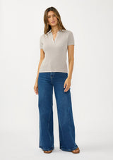 [Color: Light Heather Grey] A front facing image of a brunette model wearing a grey waffle knit polo top with a collared neck and button front. 