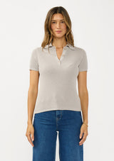 [Color: Light Heather Grey] A front facing image of a brunette model wearing a grey waffle knit polo top with a collared neck and button front. 