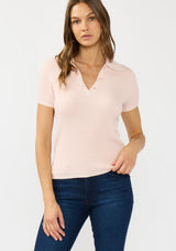 [Color: Light Pink] A front facing image of a brunette model wearing a light pink waffle knit polo top with a collared neck and button front. 