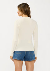 [Color: Natural] A back facing image of a brunette model wearing an off white waffle knit sweater top with a v neckline and a button front detail. 