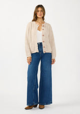 [Color: Heather Taupe] A front facing image of a brunette model wearing a beige cardigan with a button front and crew neckline. 