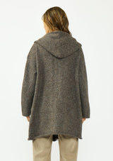 [Color: Dark Heather Brown] A back facing image of a brunette model wearing a brown cozy wool blend coatigan with an oversized fit, hoodie, and side pockets. 