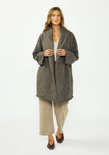 [Color: Dark Heather Brown] A front facing image of a brunette model wearing a brown cozy wool blend coatigan with an oversized fit, hoodie, and side pockets. 