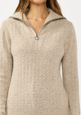 [Color: Heather Cement] A detail image of a brunette model wearing a brown pointelle knit sweater with a half zip up. 