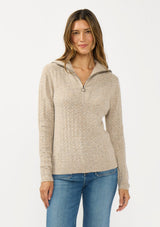 [Color: Heather Cement] A front facing image of a brunette model wearing a brown pointelle knit sweater with a half zip up. 