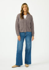 [Color: Mocha] A front facing image of a brunette model wearing a knit cardigan with a button front and v neckline. Paired with dark brown denim. 