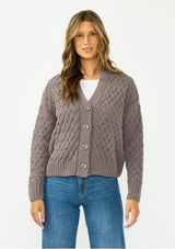 [Color: Mocha] A front facing image of a brunette model wearing a knit cardigan with a button front and v neckline. Paired with dark brown denim. 
