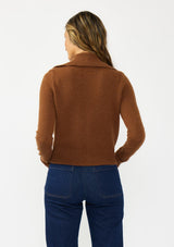 [Color: Brown] A back facing image of a brunette model wearing a brown cropped sweater with a wide collar, button front, and ribbed trim. Styled with a dark was denim. 