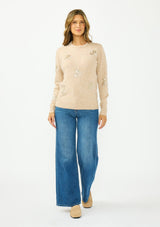 [Color: Heather Sand] A front facing image of a brunette model wearing a light brown crew neck sweater with sequins and embellishment. 
