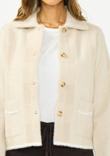 [Color: Natural/Taupe] A detail image of a brunette model wearing a beige plaid sweater jacket with a fuzzy texture, collared neck, button front, and patch pockets. 