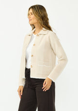 [Color: Natural/Taupe] A side facing image of a brunette model wearing a beige plaid sweater jacket with a fuzzy texture, collared neck, button front, and patch pockets. 