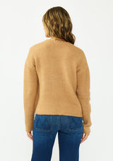 [Color: Camel] A back facing image of a brunette model wearing a camel brown cardigan with an open front, patch pockets, and blanket stitch trims. Styled over a white tee and dark wash denim. 