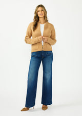 [Color: Camel] A front facing image of a brunette model wearing a camel brown cardigan with an open front, patch pockets, and blanket stitch trims. Styled over a white tee and dark wash denim. 