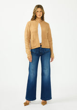 [Color: Camel] A front facing image of a brunette model wearing a camel brown cardigan with an open front, patch pockets, and blanket stitch trims. Styled over a white tee and dark wash denim. 